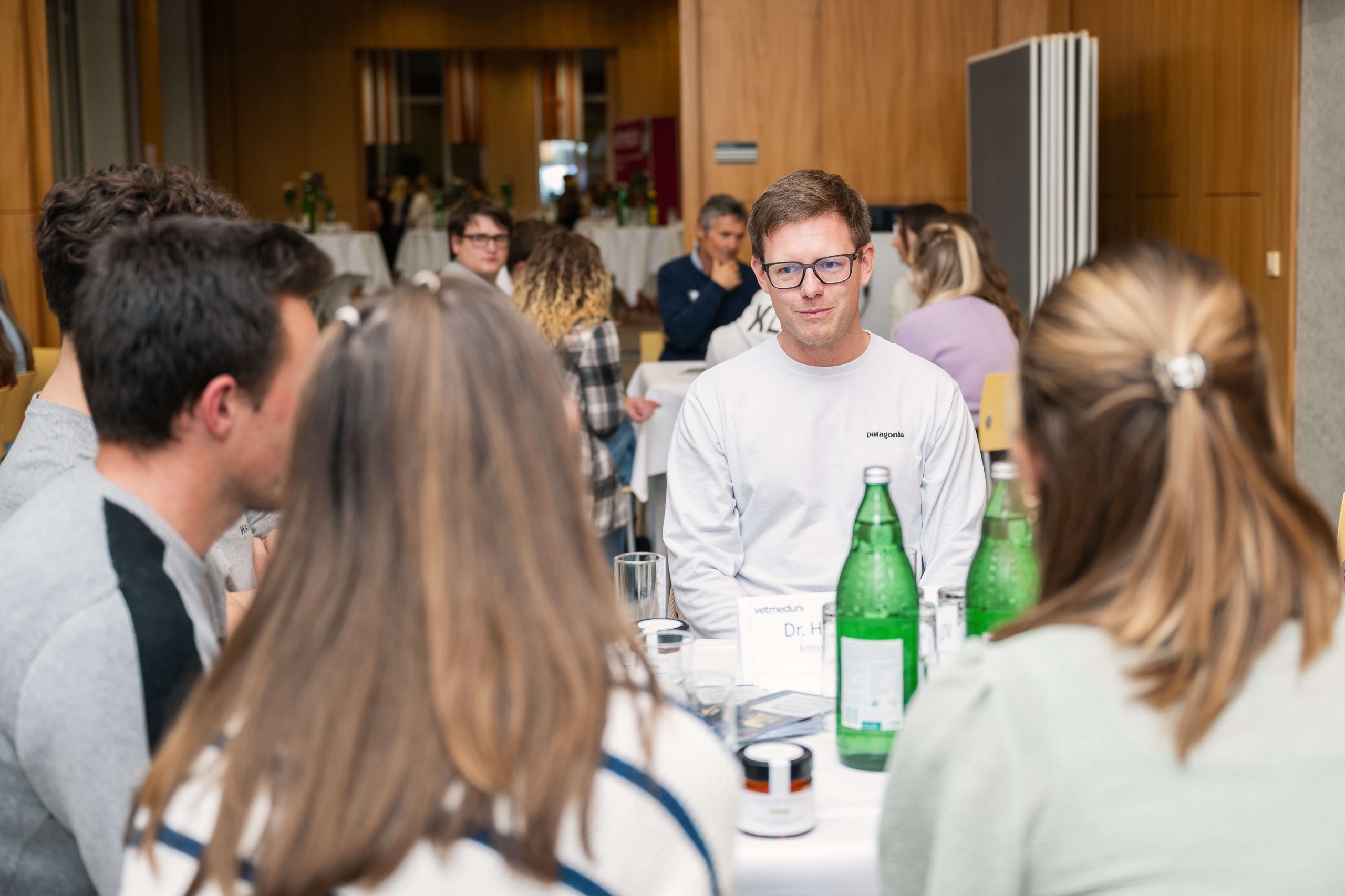 Studierende sitzen zusammen mit einem Experten aus Tirol am Tisch und tauschen sich aus.