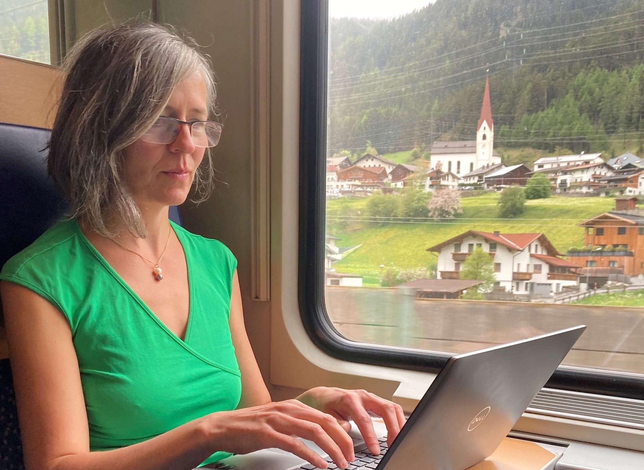 Annette Nigsch sitzt im Zug und arbeitet auf ihrem Notebook